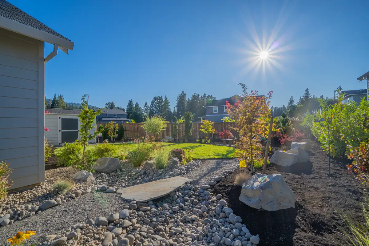 Dry creek bed landscape design with natural boulders and plantings by CreekView Landscape in Wilsonville Oregon