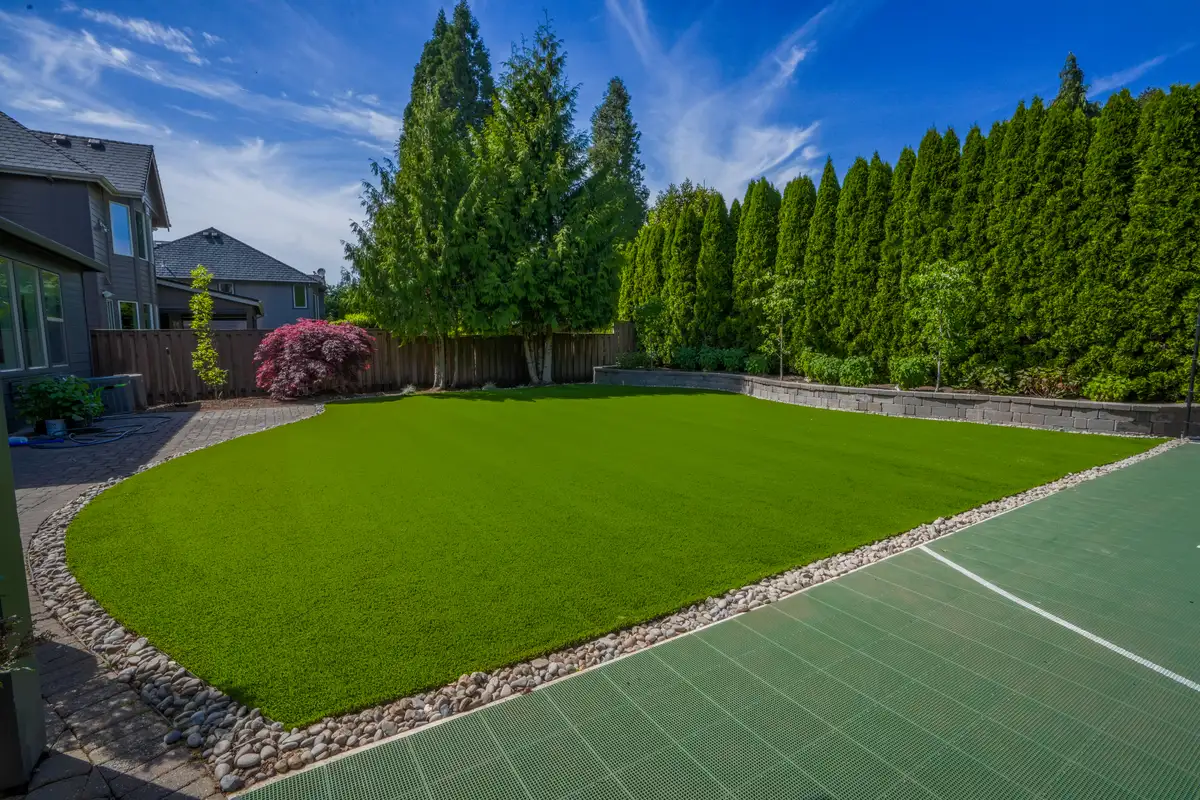Wide-angle artificial turf installation with retaining wall by CreekView Landscape in Oregon